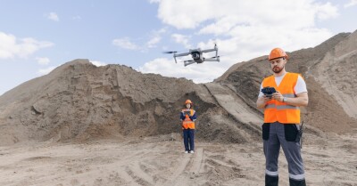 Team specialists operator inspecting construction site, industrial open pit mine sand quarry. Drone industry inspection from pilot engineer.